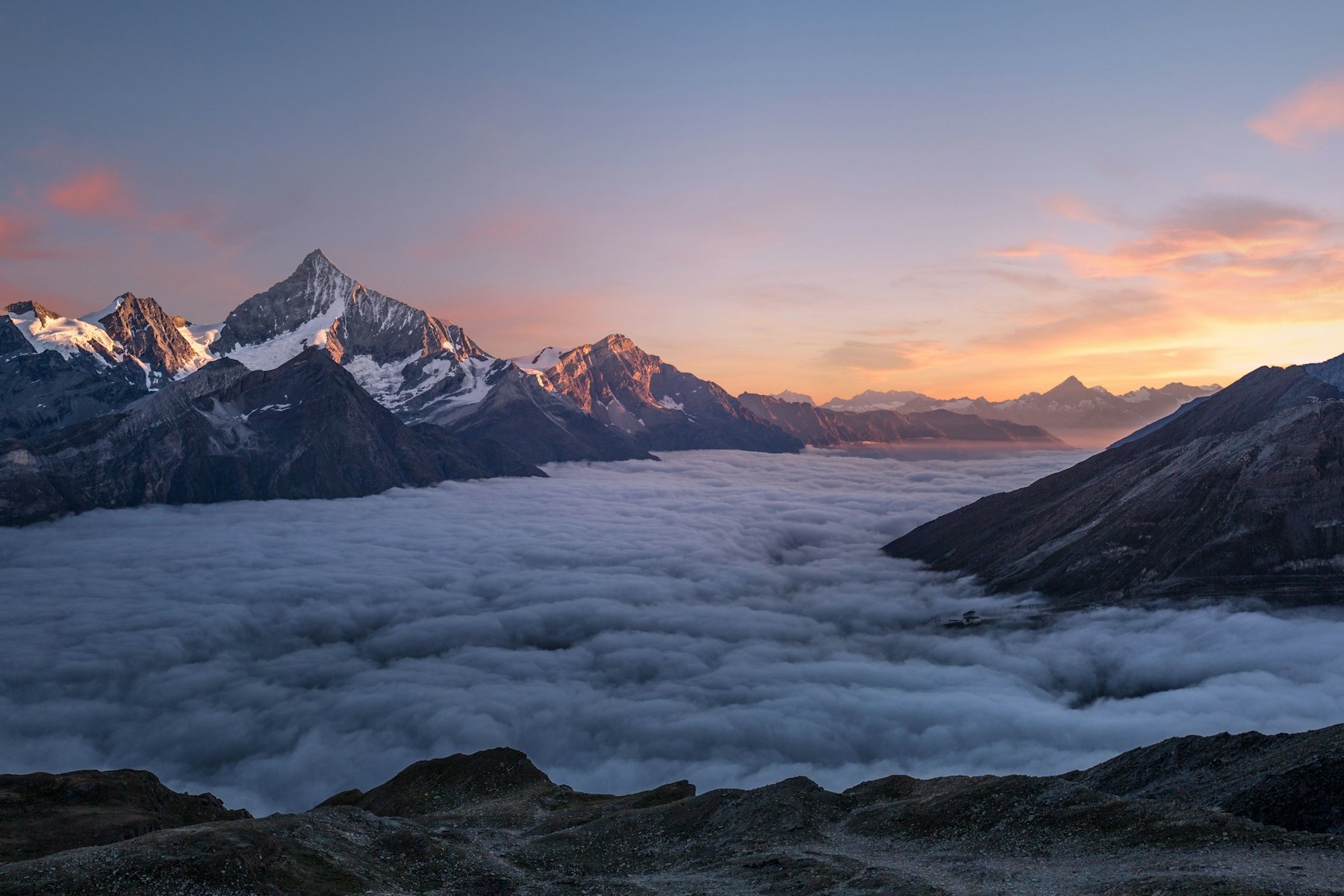 Alpengipfel über einem Nebelmeer bei Sonnenaufgang